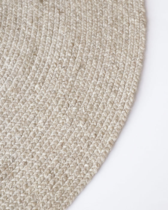 Tairua Round Floor Rug in Natural Straw, close-up of the curved edge and wool and viscose weave