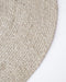 Tairua Round Floor Rug in Natural Straw, close-up of the curved edge and wool and viscose weave